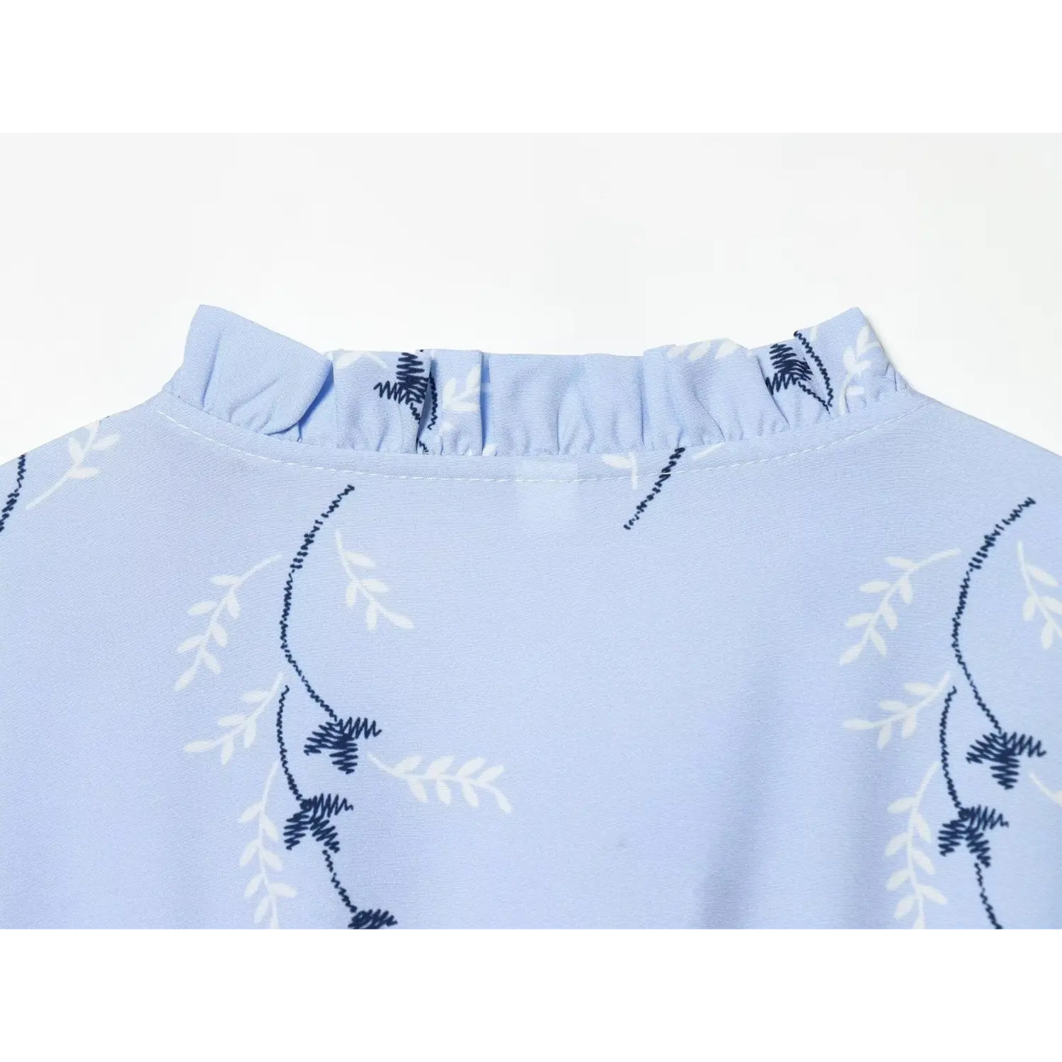 Close‑up of back ruffle collar and stitching on light blue floral dress