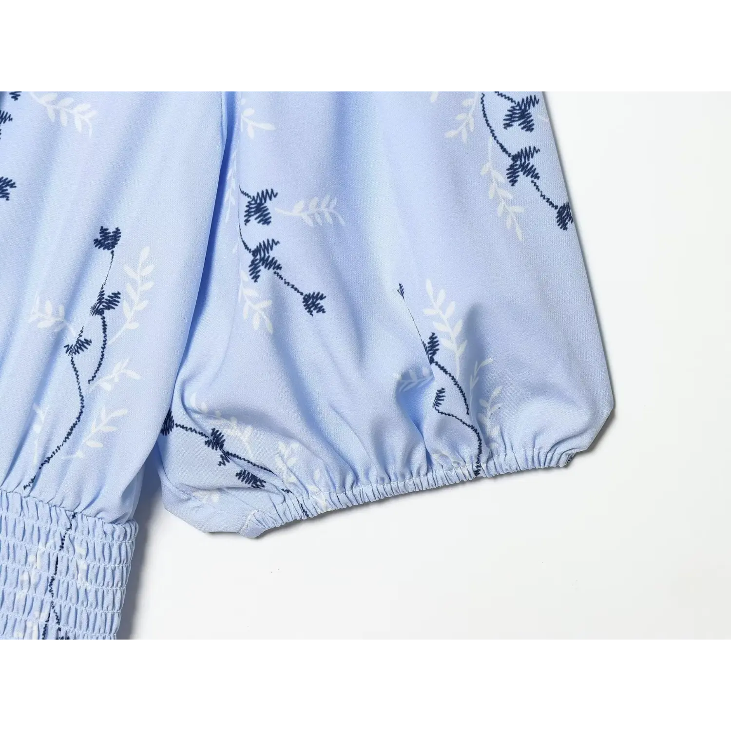 Close‑up of elastic cuff on puff short sleeve, light blue floral printed fabric