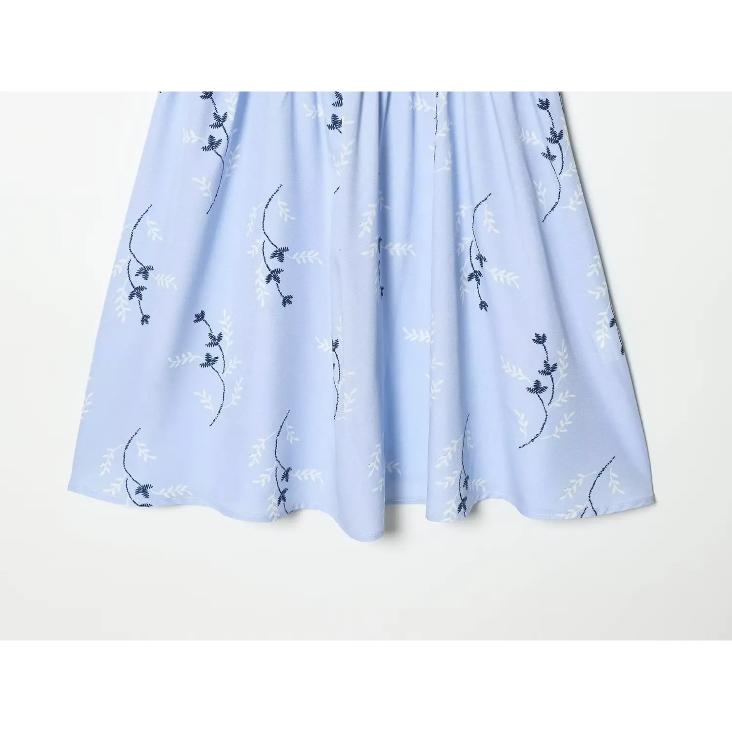 Overhead shot of flowy skirt section, light blue fabric with dark blue vine floral print