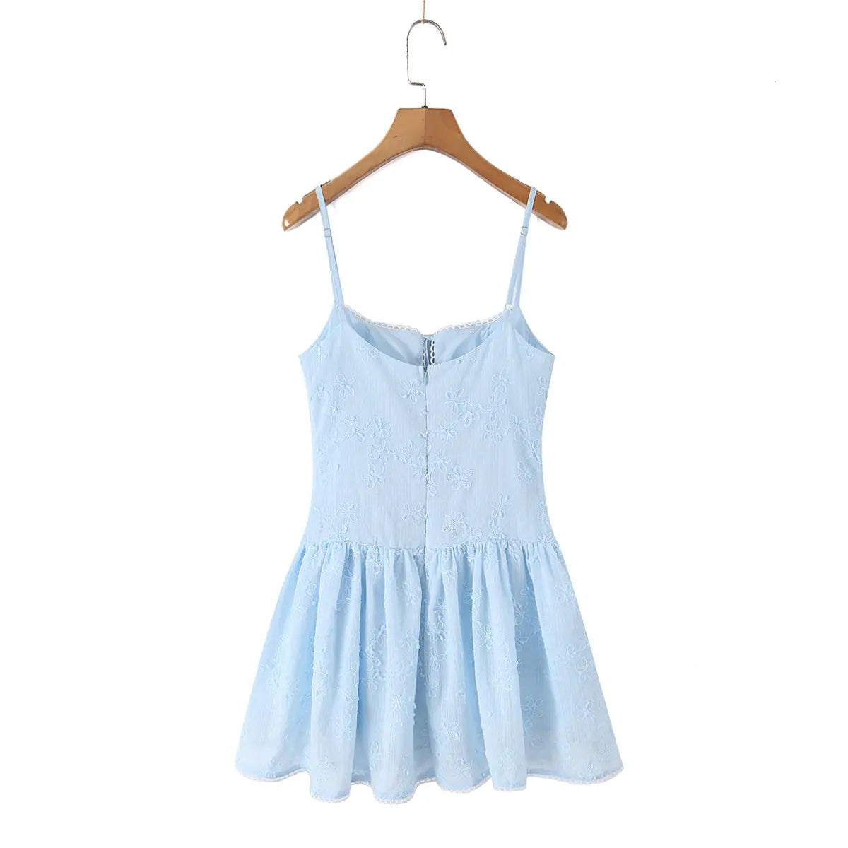 Back view of a light blue spaghetti strap dress with floral embroidery, hanging on a wooden hanger.
