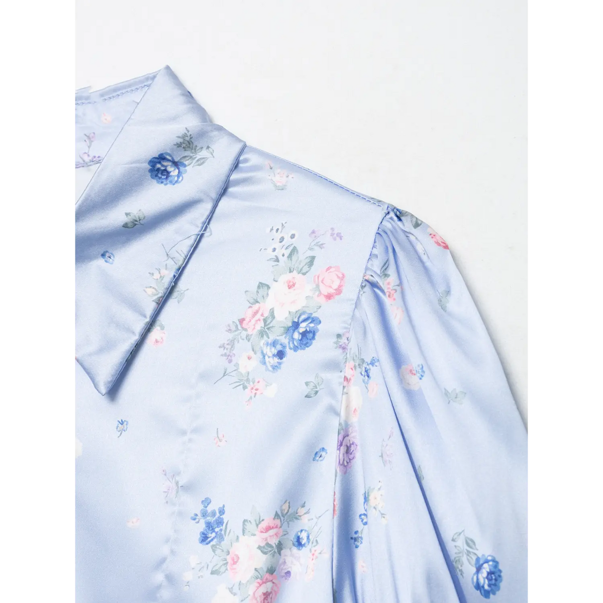 Close-up of lapel collar and shoulder fabric of light blue floral maxi dress, smooth satin texture, vintage ditsy rose print