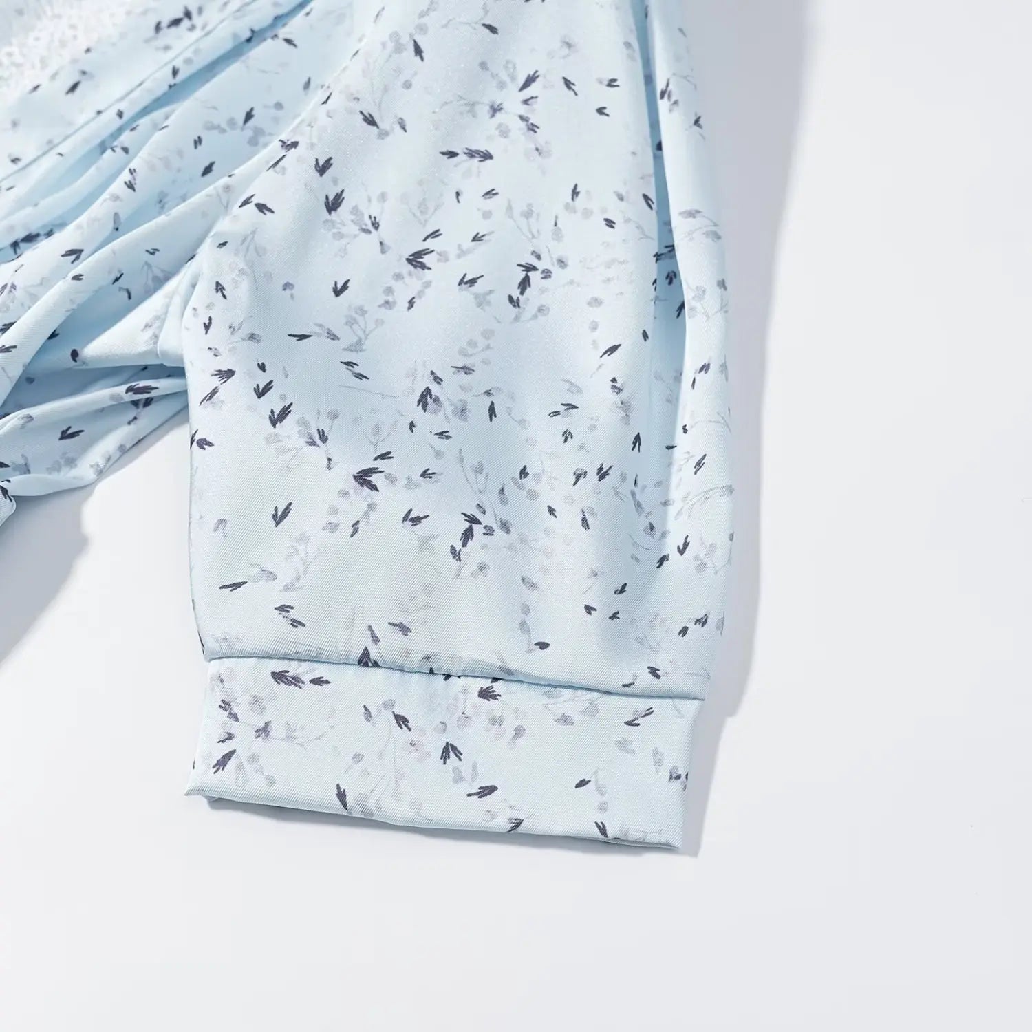 Close‑up short cuffed sleeve fabric texture for light blue ditsy floral print maxi dress