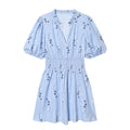 Flat‑lay front view of light blue floral print mini dress with ruffle v‑neck, puff short sleeves and smocked waist