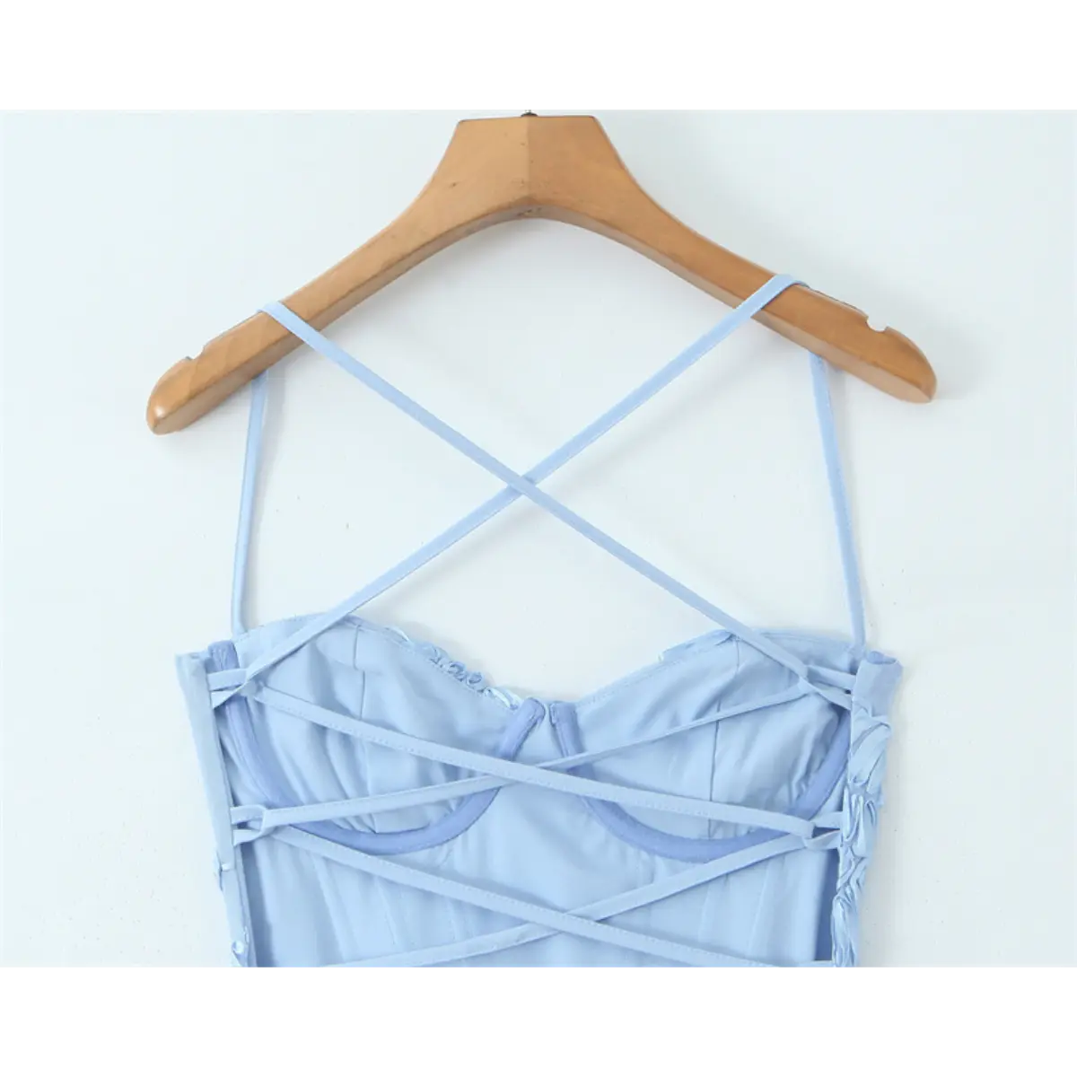 Close-up of the lace-up corset back of a light blue gown, with crisscross straps and boned bustier structure.