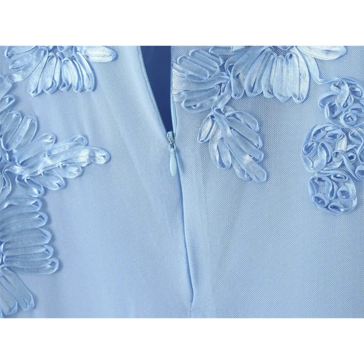 Close-up of the invisible side zipper on a light blue mermaid gown, with 3D floral embroidery on the mesh overlay.