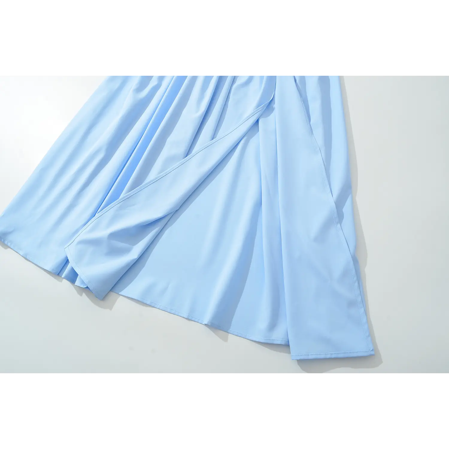 Flat lay partial view flowy maxi skirt fabric and inner slip light blue halter corset dress