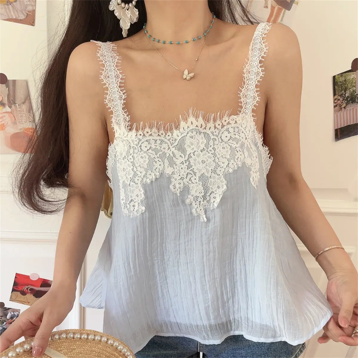Front view of the light blue cami top with intricate floral lace detailing across the bust.