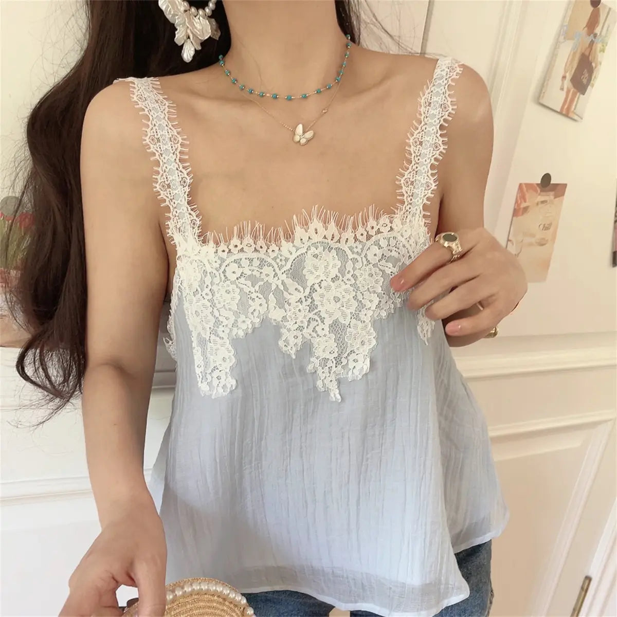 The light blue lace cami top styled with denim shorts and accessories.