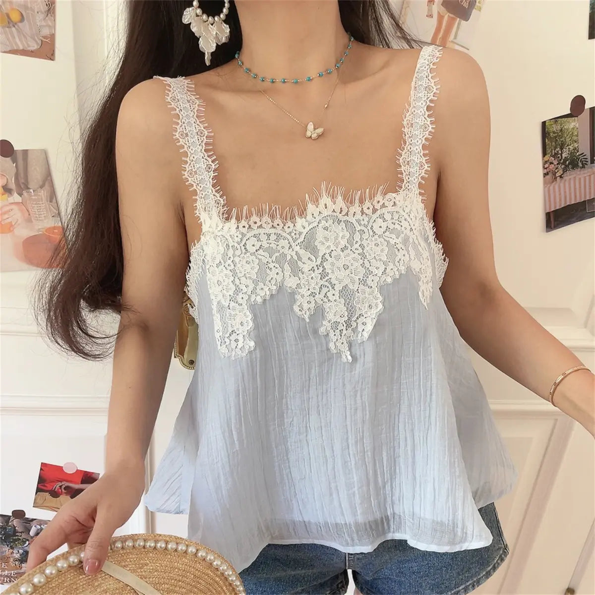 Three-quarter view of the light blue lace cami top, showing the flowy silhouette.