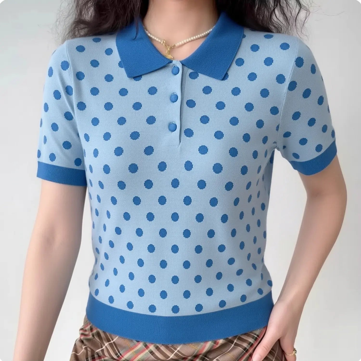 Lifestyle shot of model wearing the light blue polka dot polo knit top, showing the full silhouette and color contrast