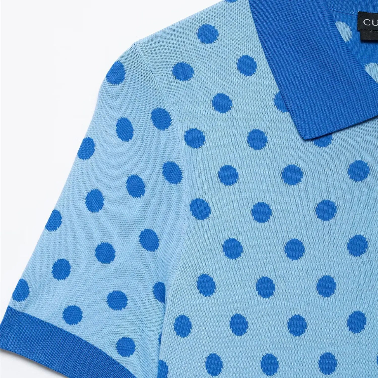 Full back view on white background of the light blue polka dot polo knit top