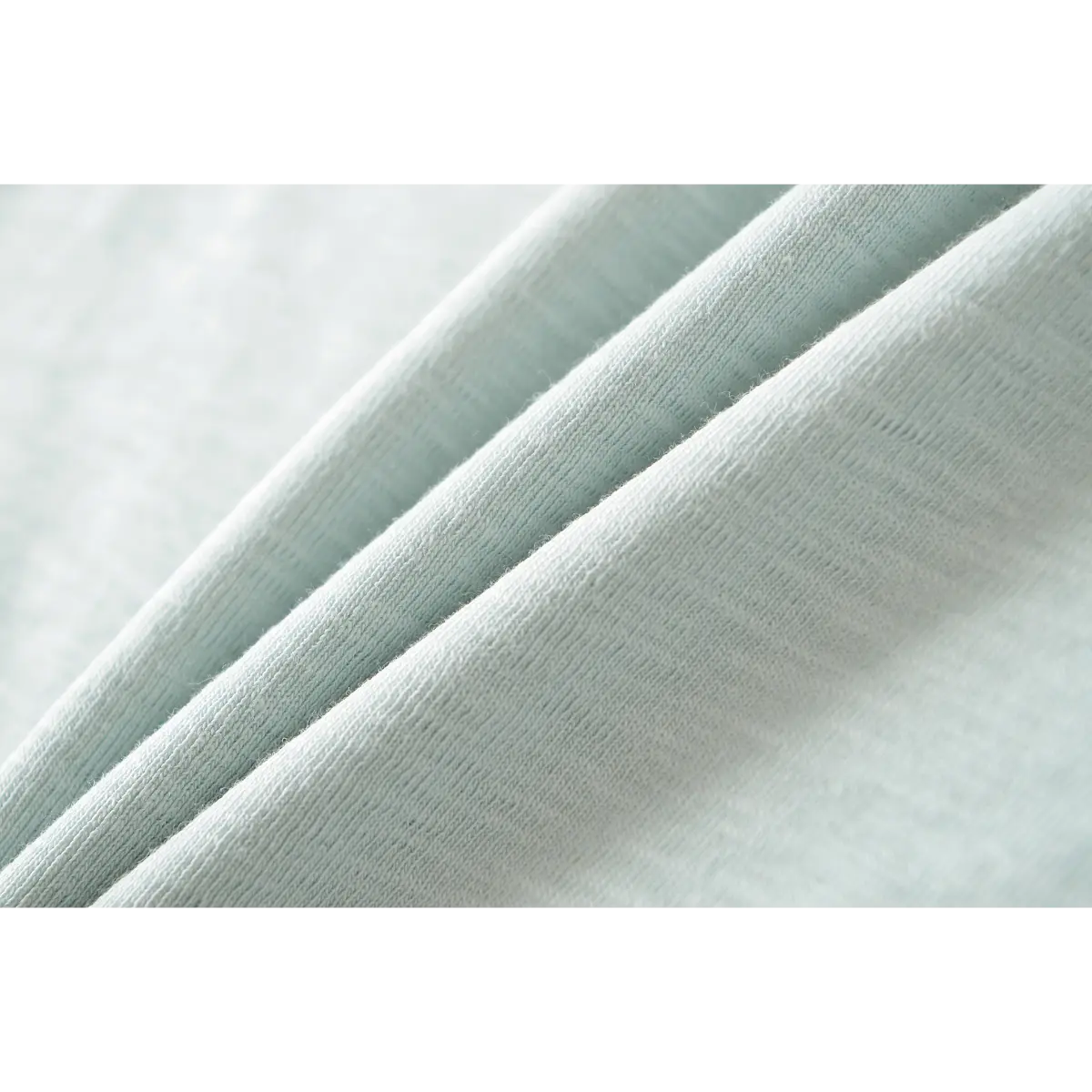 Close-up of the fine ribbed texture of the light blue t-shirt fabric