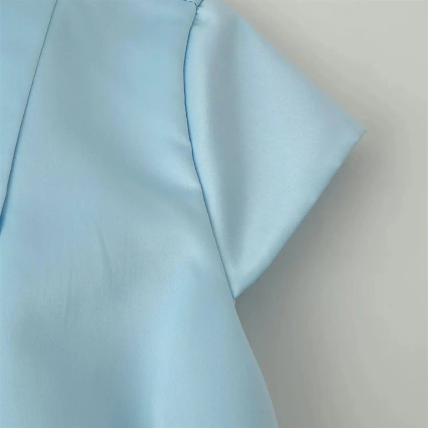 Cap short sleeve partial shot, soft shiny satin texture, clean folded sleeve edge seaming