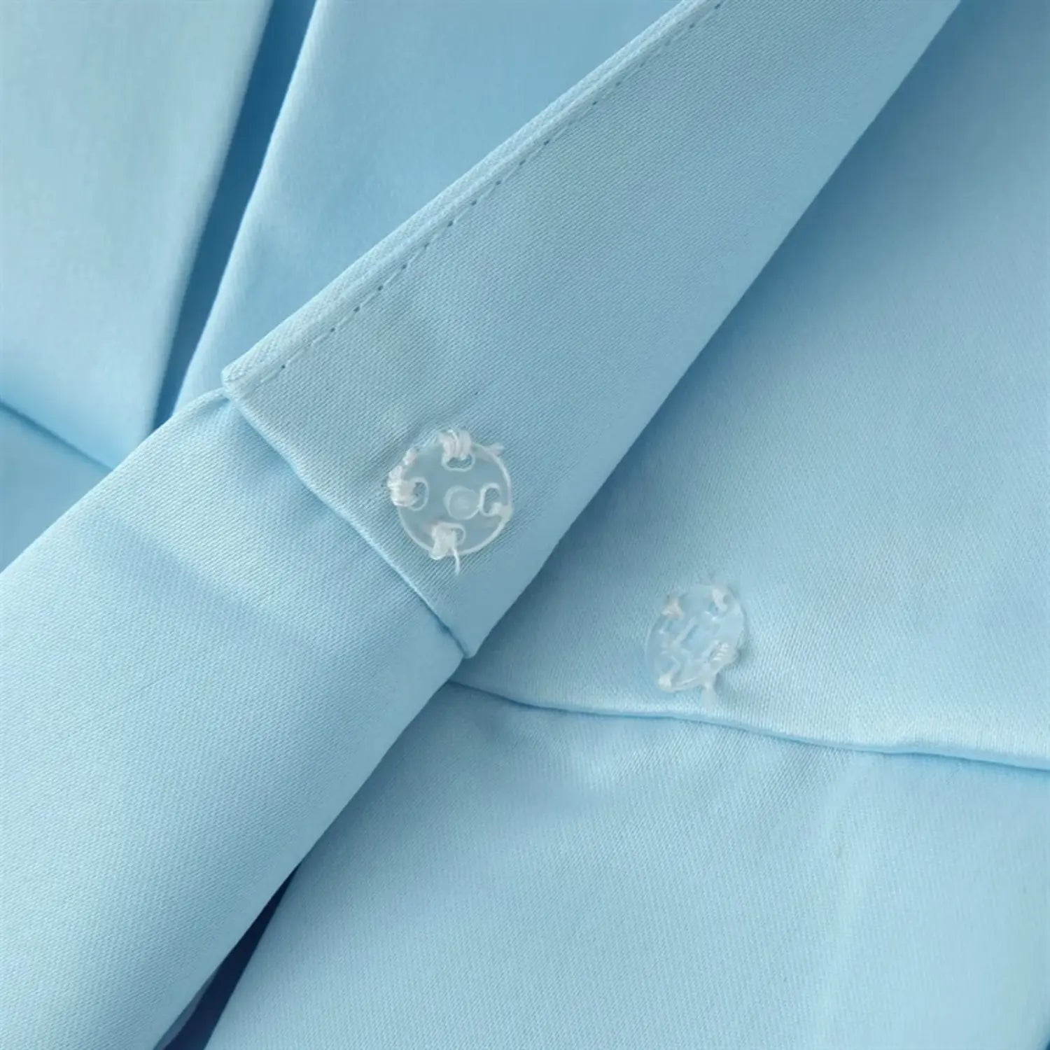 Front placket invisible clear plastic snap fastener extreme close-up, neat edge binding along lapel