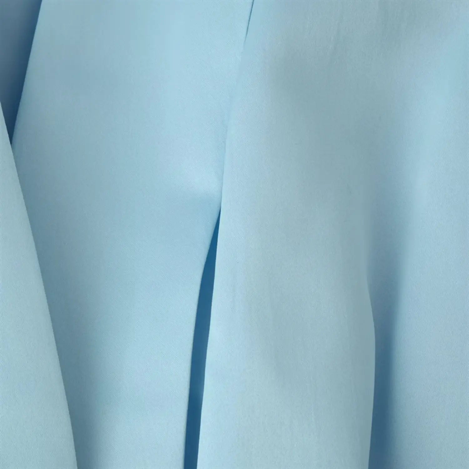 Center front deep V folded lapel close-up, vertical tailored pleats, reflective satin weave texture