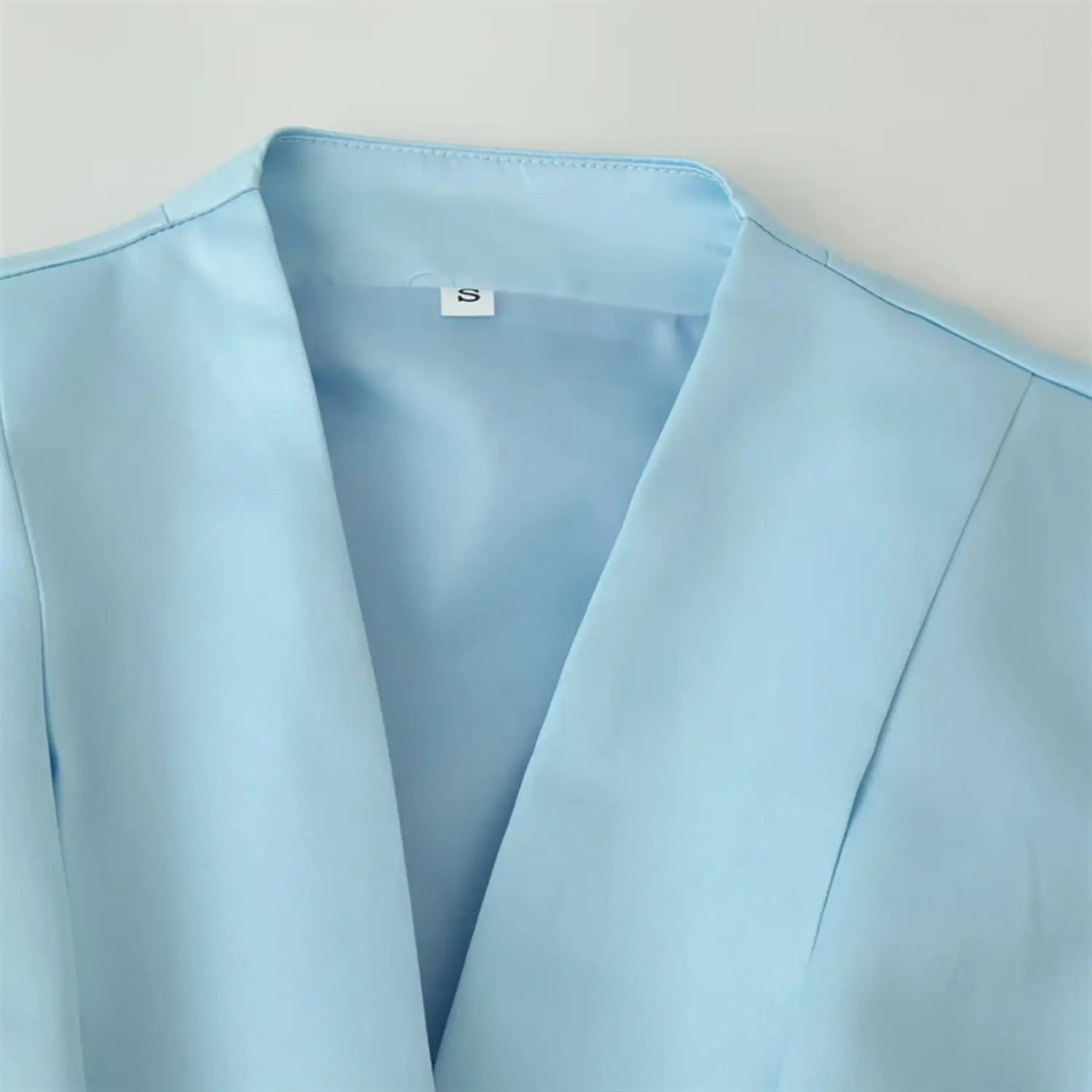 Front lapel & deep V neck close-up, smooth glossy satin lining, inner size label, neat folded lapel stitching