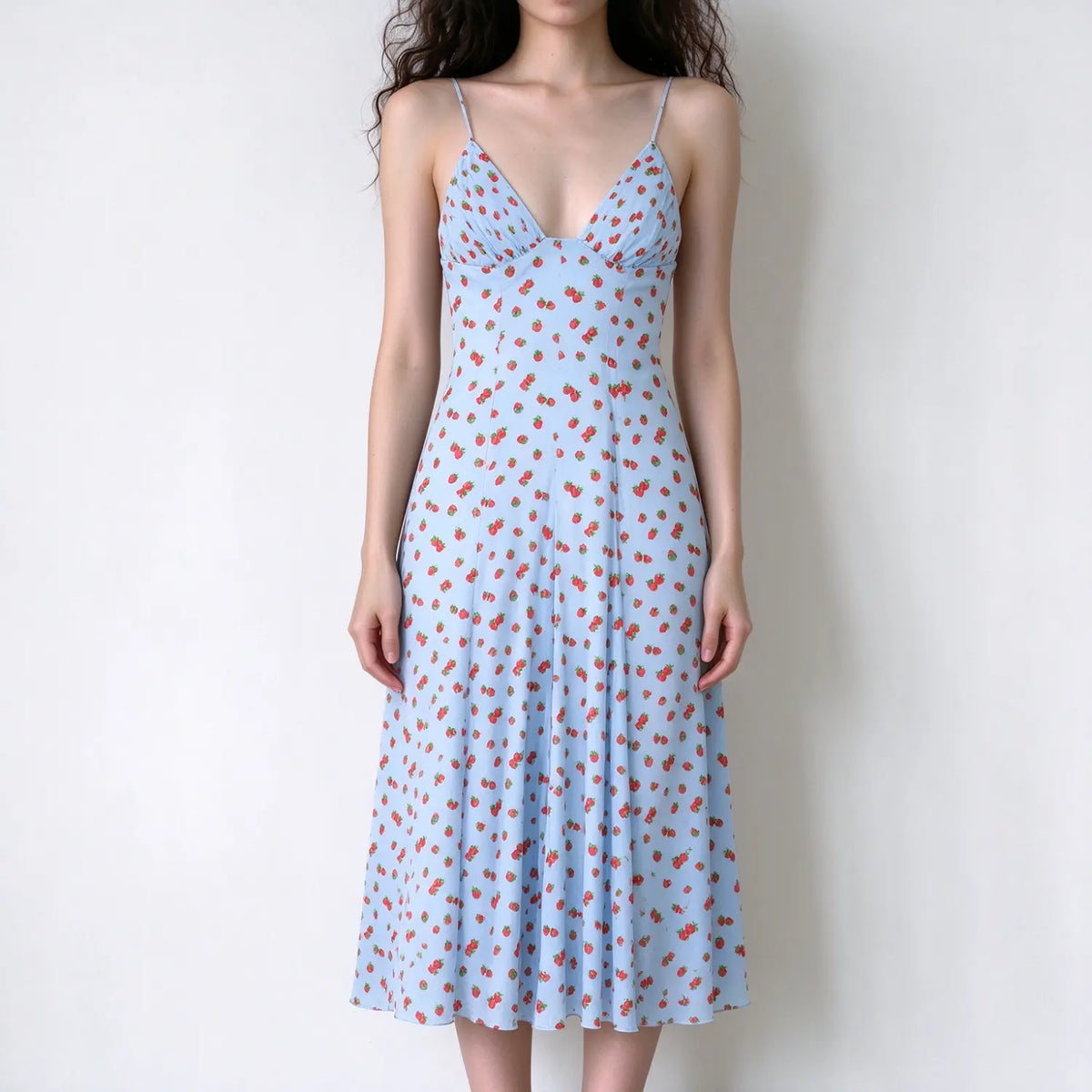 Model wearing light blue strawberry print spaghetti strap maxi dress, deep v neckline, flowy skirt, white background