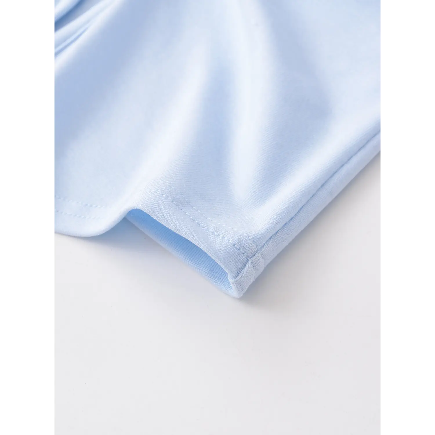 Light blue double twist sleeveless tank hem binding flat close-up, neat double line overlock soft stretch knit fabric edge stitching white background shot

