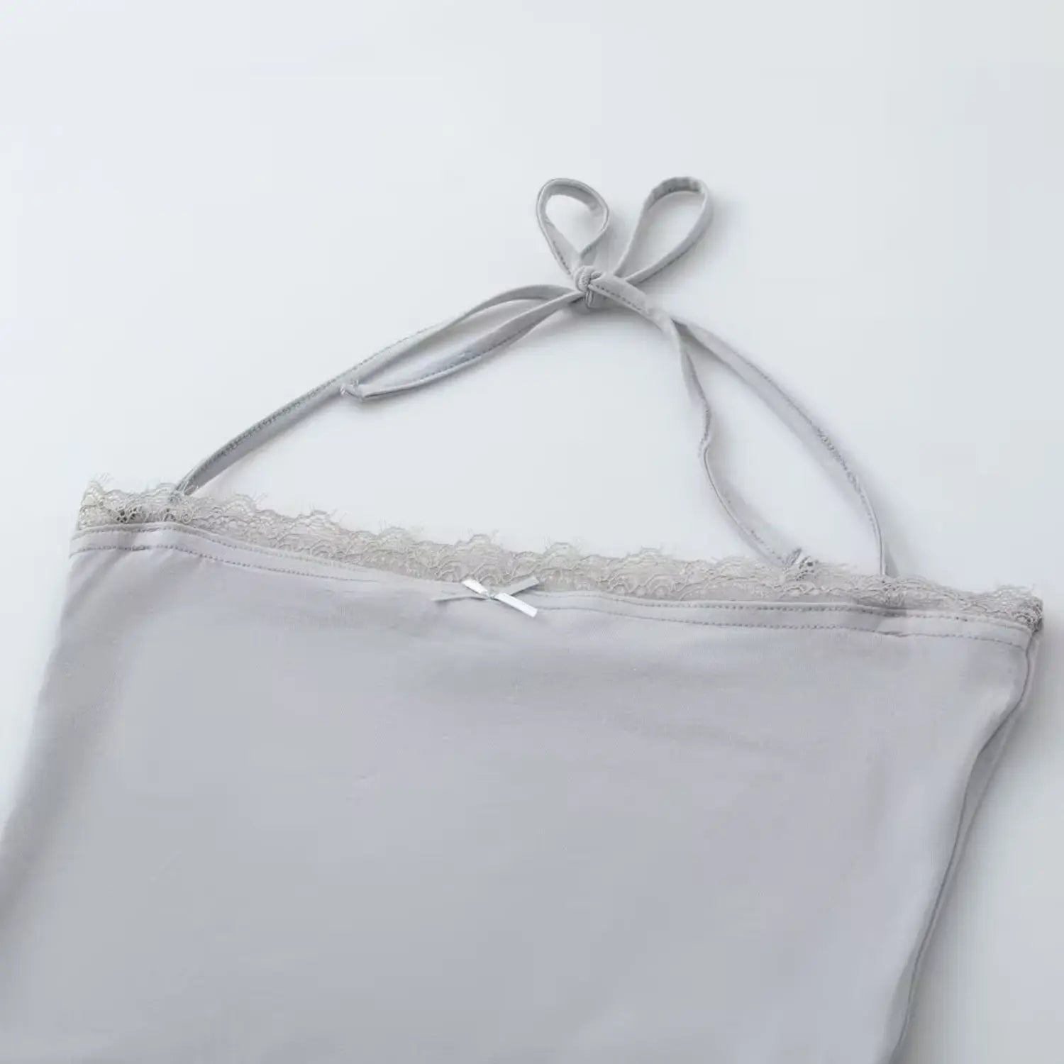 Flat lay shot light gray halter camisole, close‑up of lace neckline and front bow detail