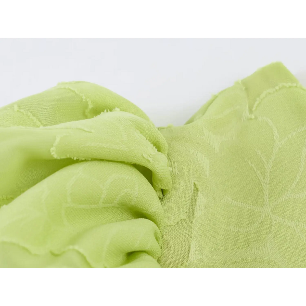 Close-up of raised floral jacquard fabric texture for light green maxi dress, raw edge floral pattern