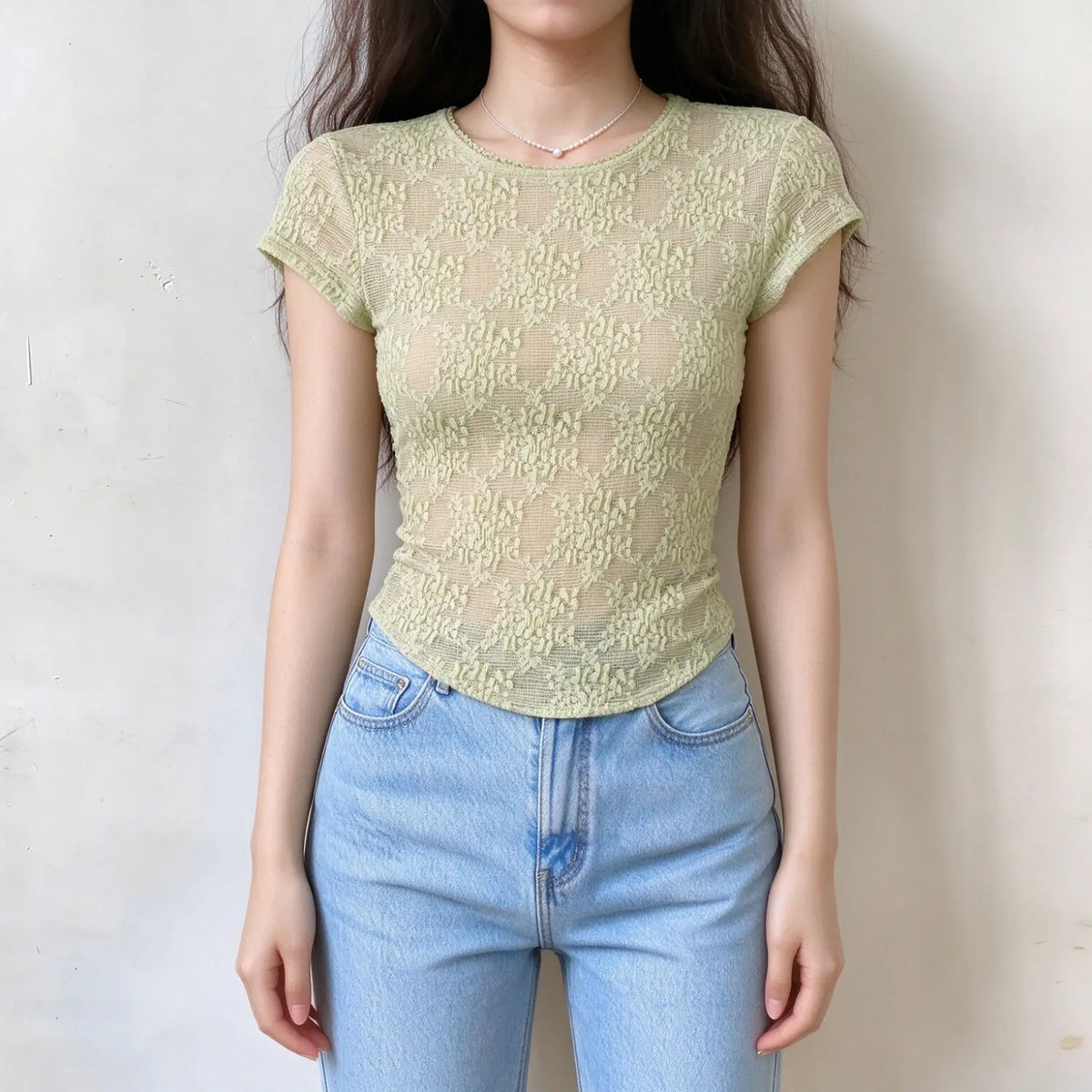 Model wearing light green sheer lace short sleeve top, round neck, diamond floral lace texture, curved hem, slim fit semi-sheer fabric