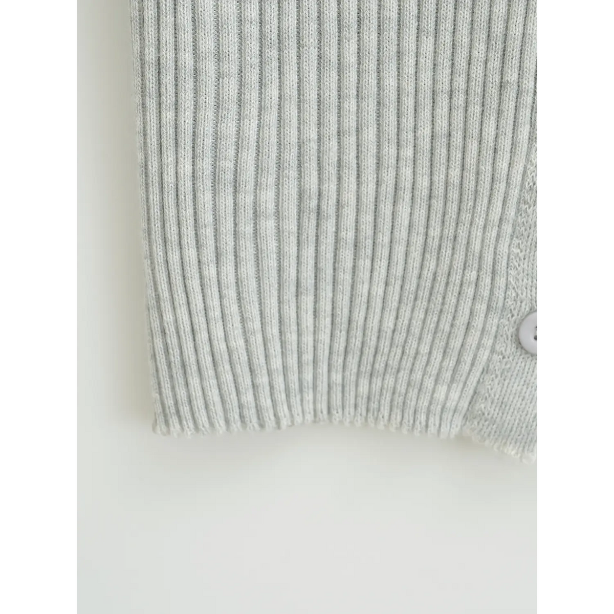 Close-up of ribbed hem on light grey lace trim knit cardigan, vertical stretch rib knit detail