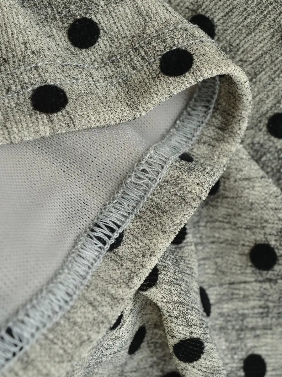 Close-up of the polka dot fabric texture, mesh lining, and finished seam on the light grey top