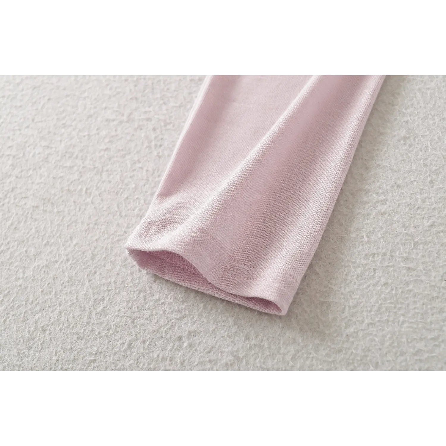 Light lilac fake two long sleeve top cuff flat close-up, double rib overlock sleeve hem soft modal stretch knit neat stitching white background shot