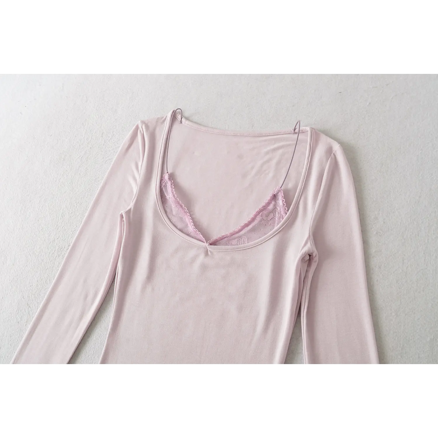Light lilac fake two long sleeve top u neck macro flat close-up, scalloped lace thin straps reinforced binding stitching wide u neck overlock craft white background detail shot