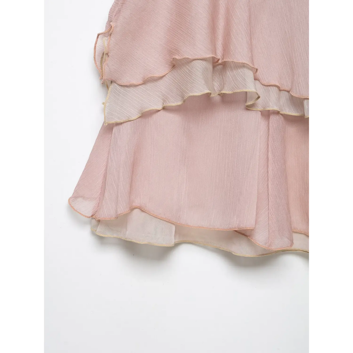 Product closeup of light pink sheer chiffon mini skirt, layered frilled hem with contrast fine trim, clean white background