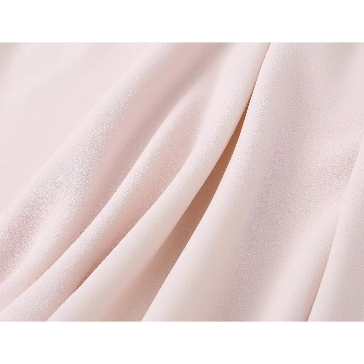 Close-up view of light pink chiffon fabric, highlighting its smooth texture and natural drape.