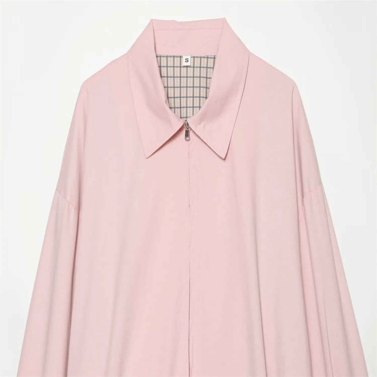 Close-up of collar and zipper on light pink cropped outerwear