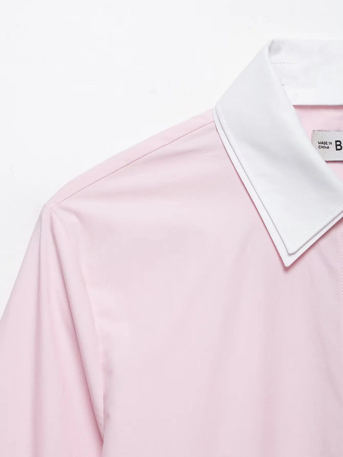 Close-up of white contrast collar and shoulder seam