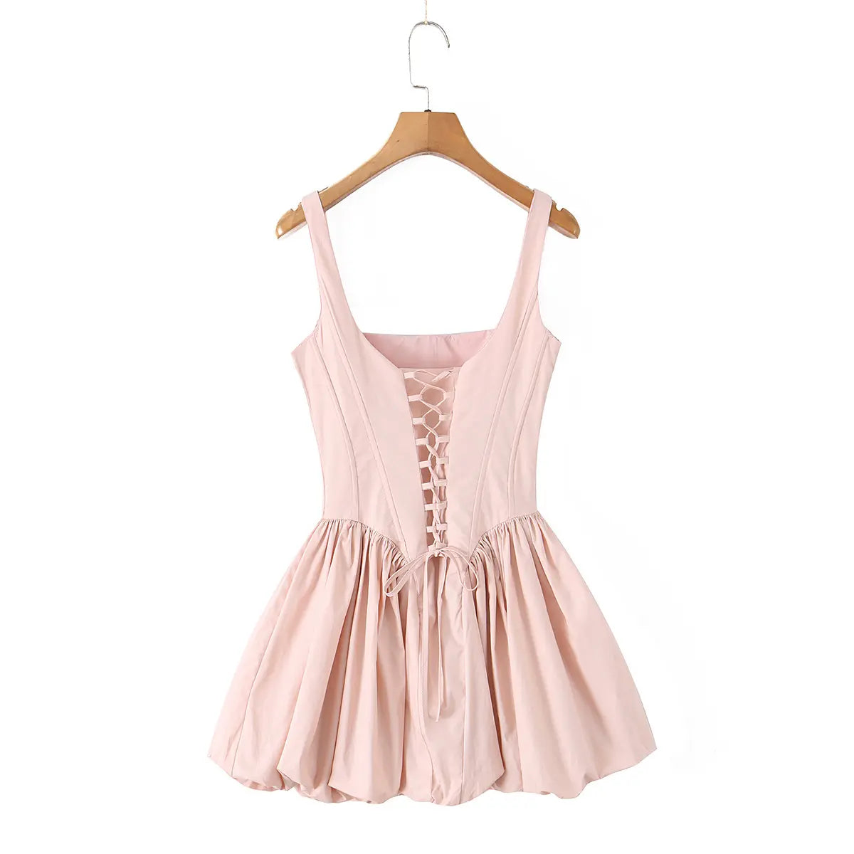 Back view of a light pink corset-style dress with a lace-up back and bubble hem.