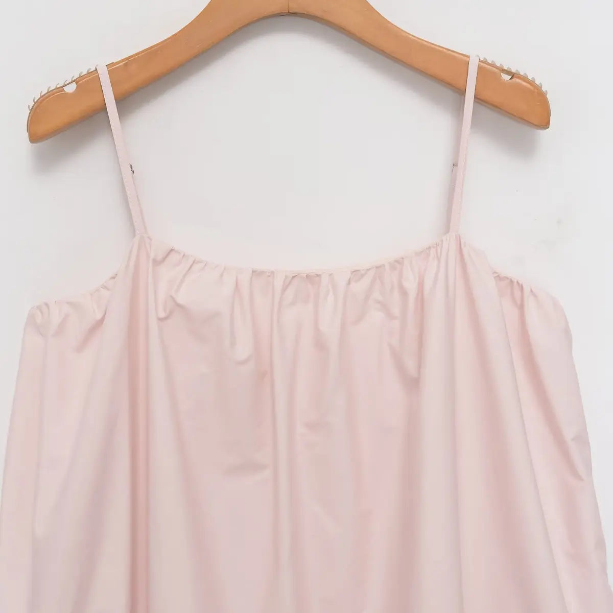 Front view of the light pink cotton dress, showing the square neckline, gathered bust, and flowy silhouette