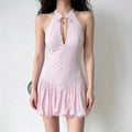 Model wearing a light pink halter-neck mini dress with a keyhole cutout, fitted bodice, and a voluminous bubble hem.