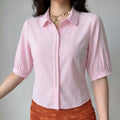 Female model wearing light pink collared cropped blouse with lace pearl front placket