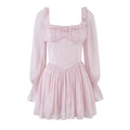 Full front flat lay of light pink mini dress, square neckline with ruffle trim, sheer long sleeves, corset boning bodice, gathered flowy chiffon skirt, pale pink lightweight fabric