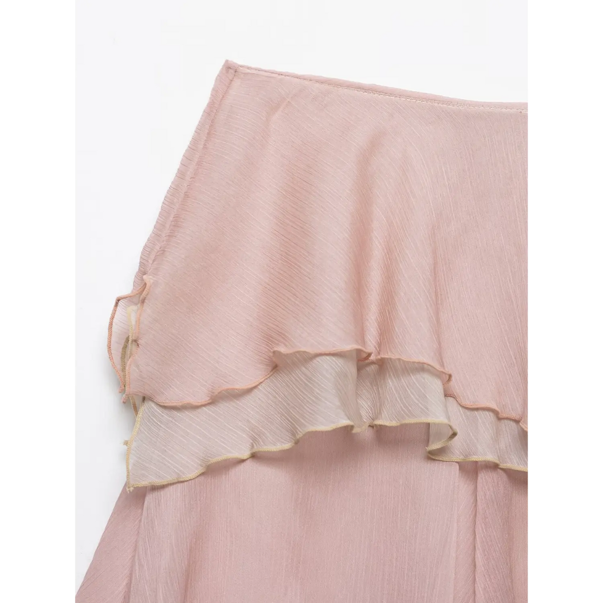 Macro detail of light pink crinkled chiffon skirt, layered frill with pale gold and pink edge stitching, white background