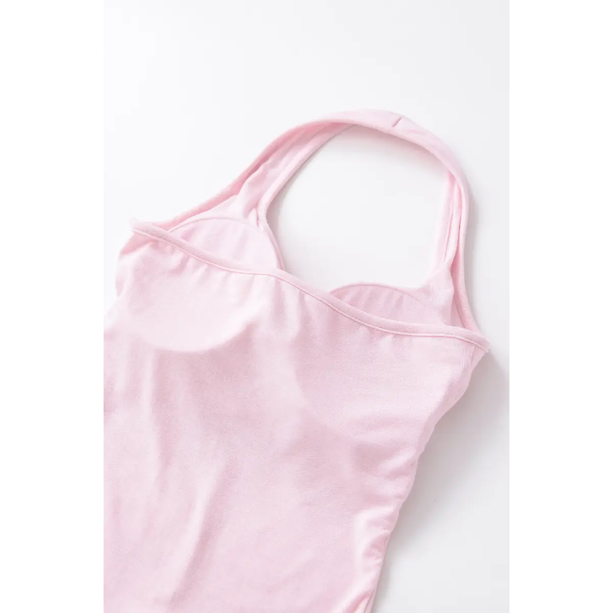 Back view of the light pink halter top, showing the bra cups and simple neckline construction.