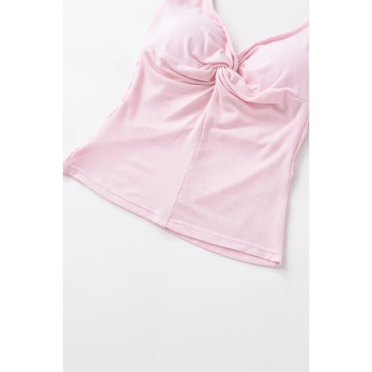 Front view of the light pink halter top, showing the twisted bust detail and cropped hem.