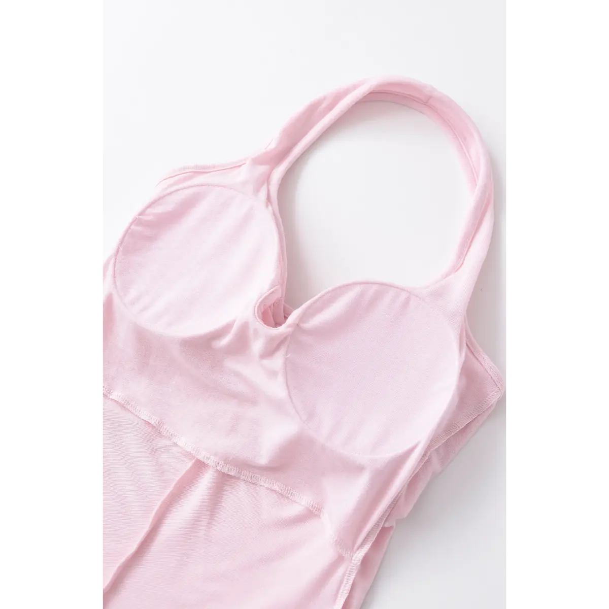 Close-up of the inner bra cups and clean finish inside the light pink halter top.