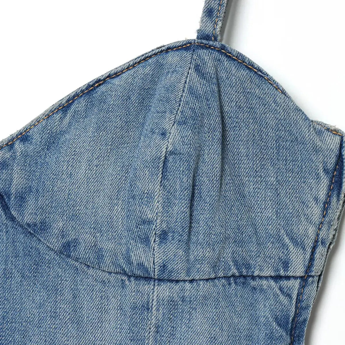Close-up of the sweetheart bustier on the light wash denim spaghetti strap dress, showing the stitching and fabric texture
