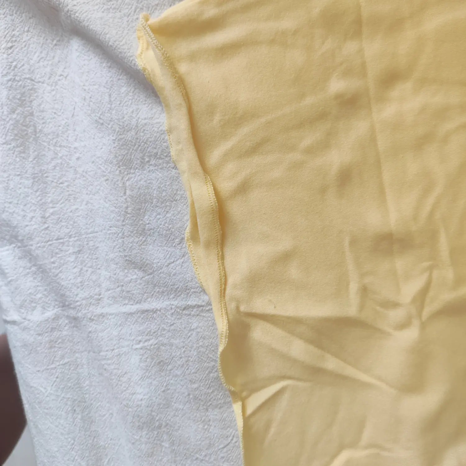 Macro shot of light yellow bodycon dress side stitching and fabric texture
