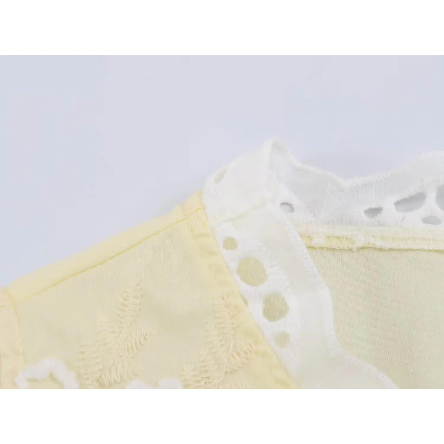 Macro view scalloped eyelet lace binding at neckline, neat edge stitching