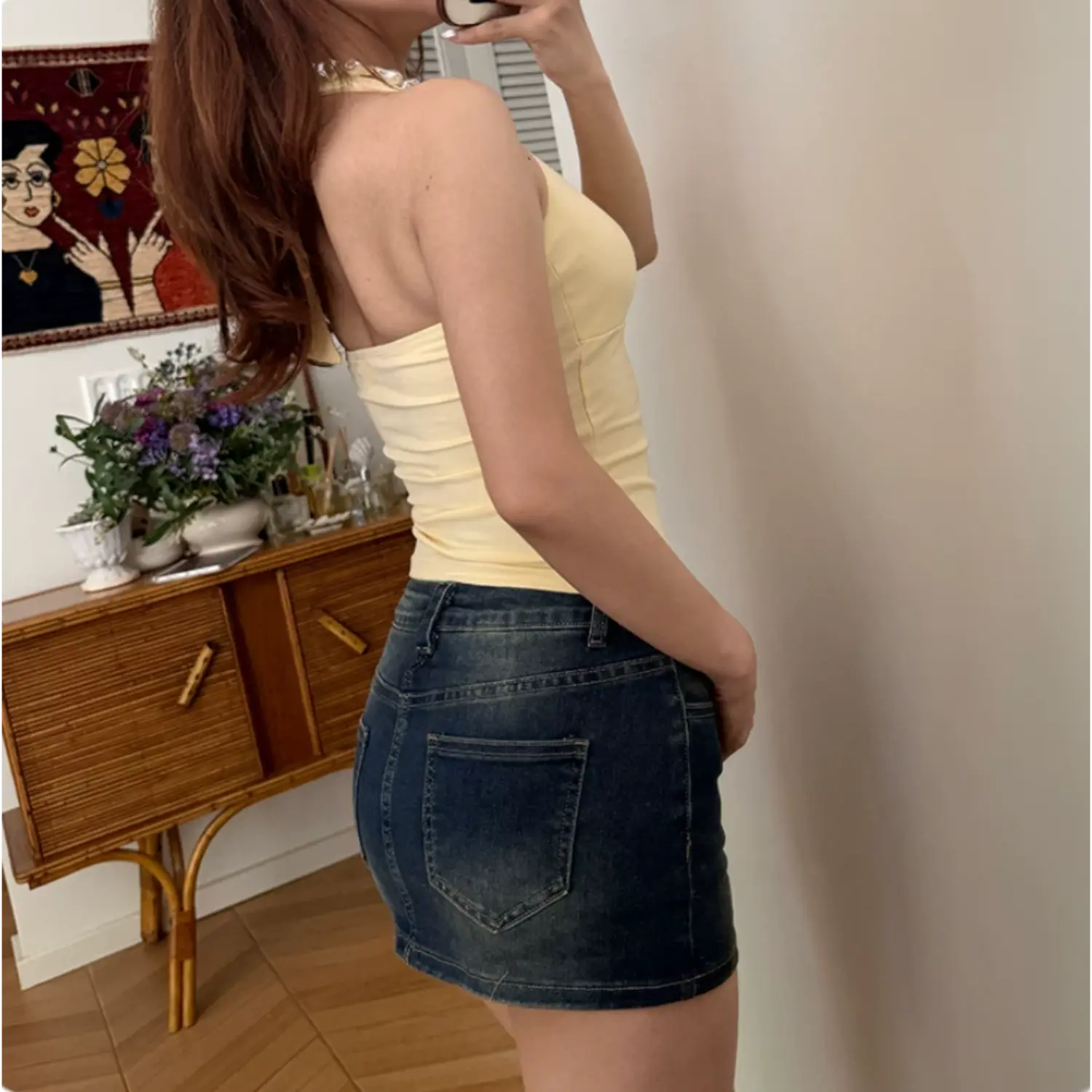 Back lifestyle shot on model of light yellow halter cami top, sleeveless fitted cropped casual tank top