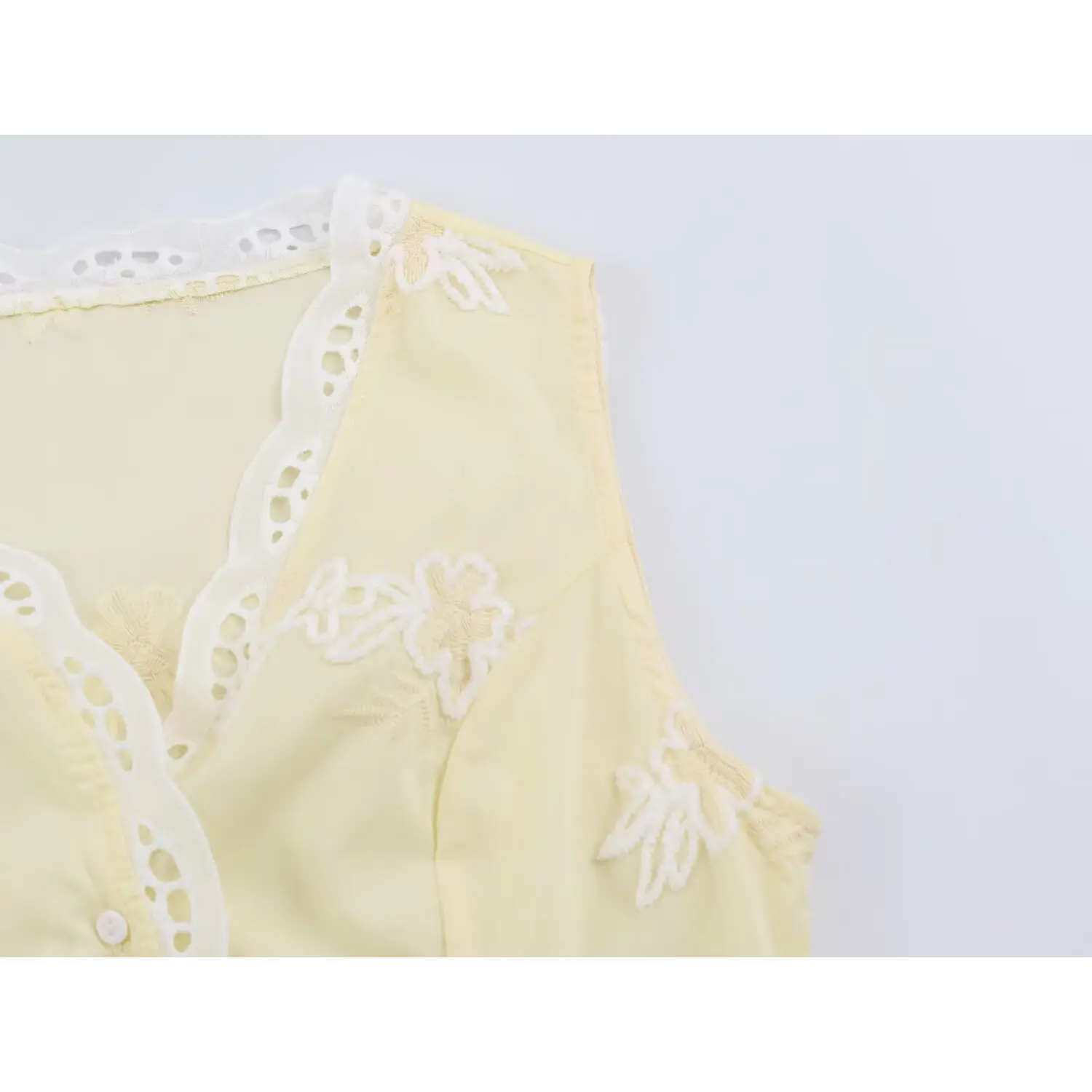 Armhole closeup, finished sleeveless edge, flower embroidery layout, lightweight woven fabric