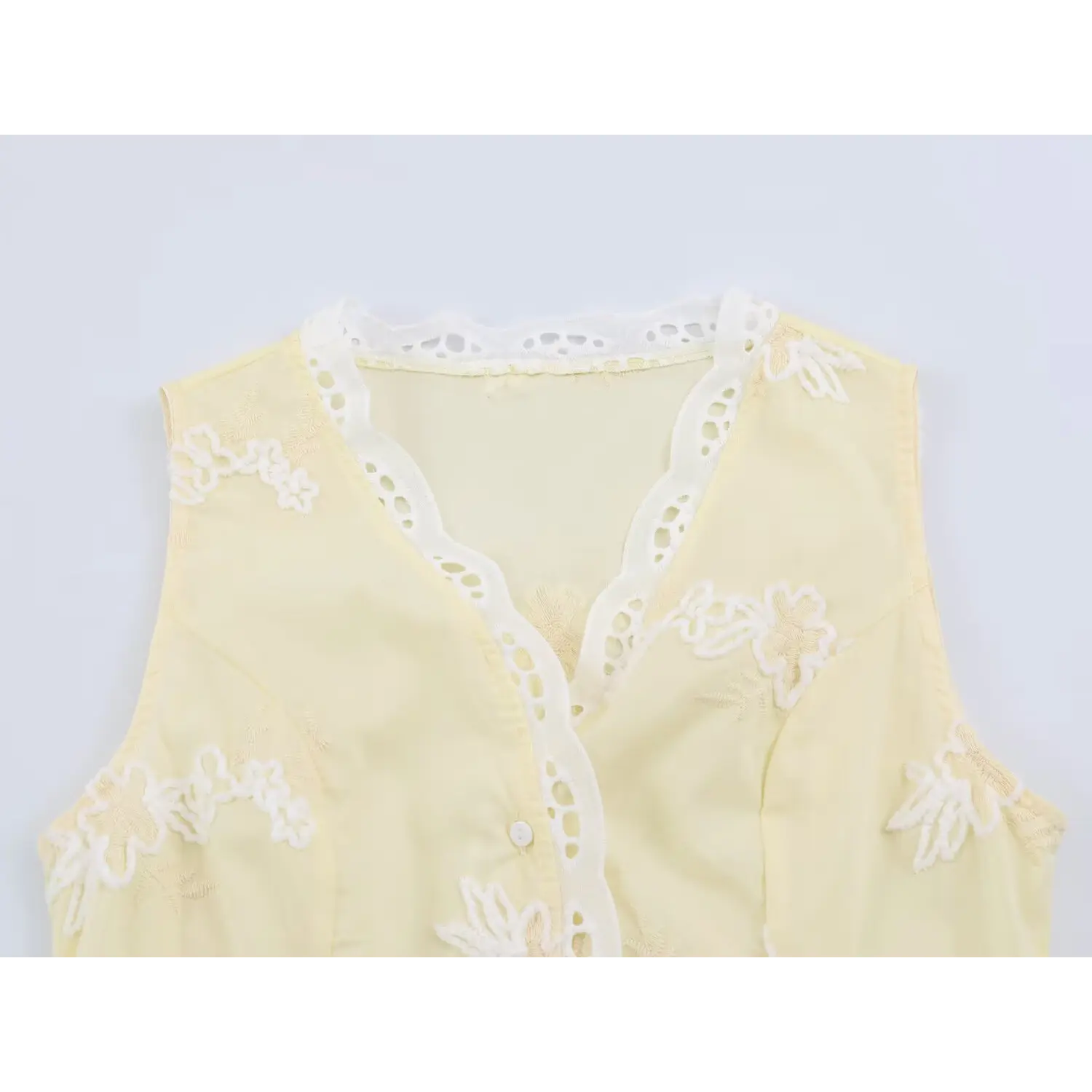 Closeup v neckline with scalloped eyelet lace trim, 3D floral applique embroidery on bust