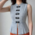 Front lifestyle shot on model of new chinese fitted denim waistcoat, stand collar, black frog buttons, peplum flare hem