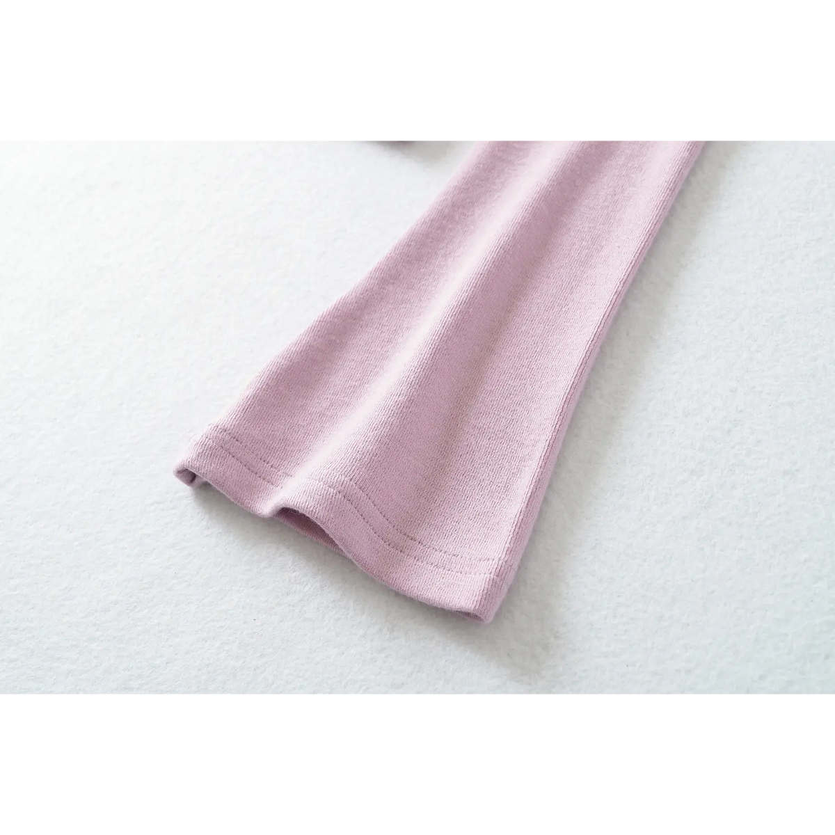 Close up of flared sleeve cuff, neat stitching on lilac stretch knit long sleeve top